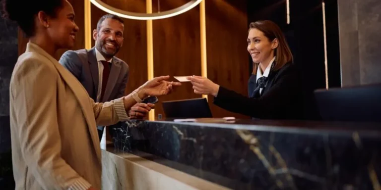 Upselling hotel Hóspede recebe atendimento na recepção de hotel durante estratégia de upselling hotel